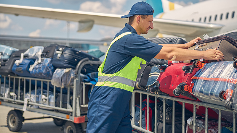 Rear view of airport worker pushing man on wheelchair in the airplane. Concept of traveling with special needs.