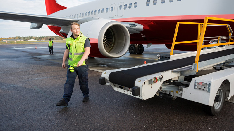 Rear view of airport worker pushing man on wheelchair in the airplane. Concept of traveling with special needs.